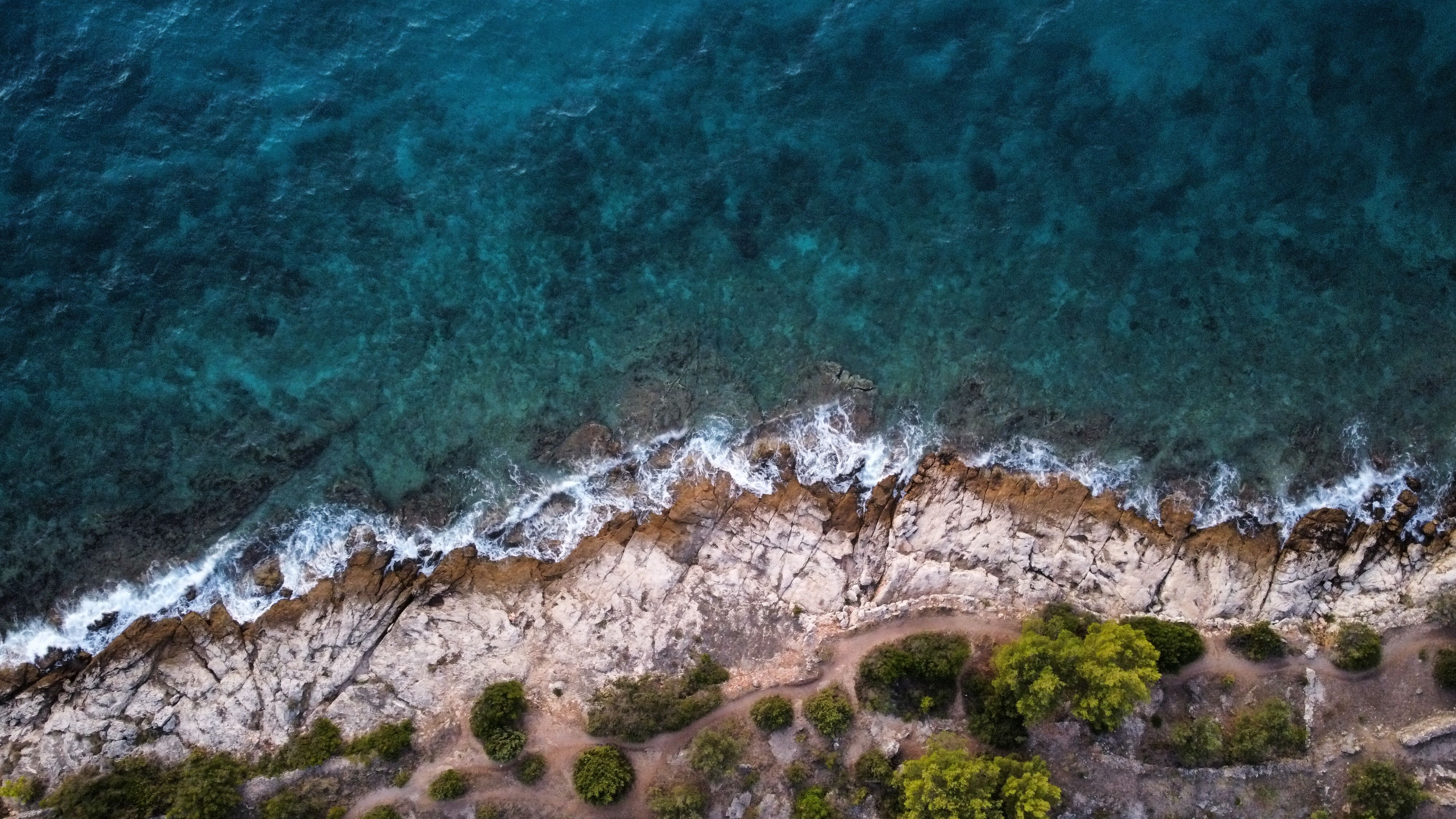 Aerial view of waves breaking along a rocky coastline