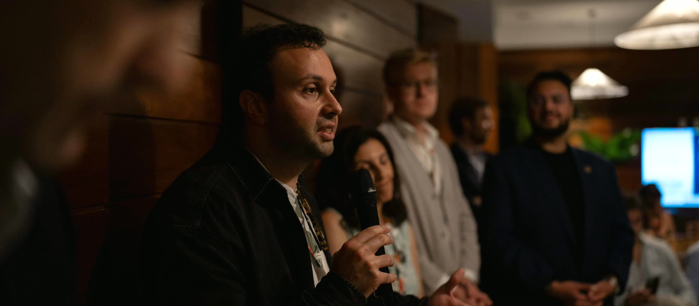 A speaker with a microphone answering questions in front of a seated audience