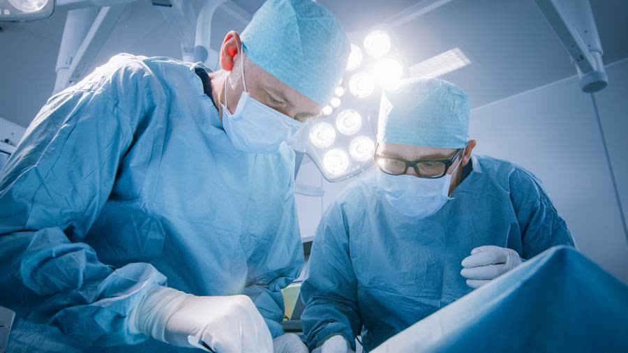 Two surgeons at work under an operating theatre light